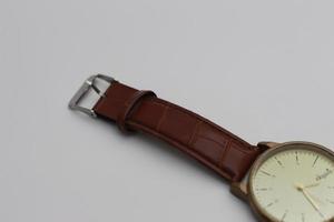 a close up of a golden watch with brown leather photo