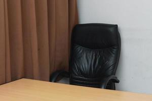 photo of a chair and desk with brown window curtains. Workspace concept photo.