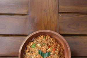 a close up Rujak Bebek or smashed fruit which is made from raw fruit crushed in a mortar and pestle and added with shrimp paste, chili and brown sugar. Indonesian traditional food photo concept.