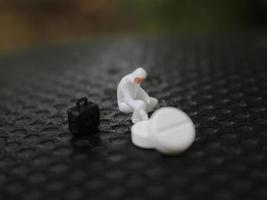 a close up of a miniature figure of a researcher researching a drug. health photo concept.