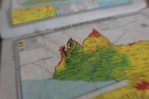 miniature figure of an explorer posing on a map or atlas photo