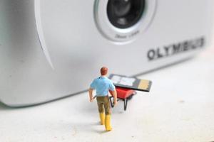 Bogor, Indonesia - Dec, 19 2022. miniature figure of a worker holding a camera memory. photo