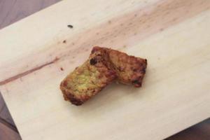 a close up of fried tempeh on a wooden cutting board photo
