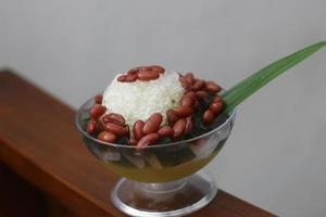 Es Kacang Merah or a cold drink made from red beans boiled with brown sugar served with coconut milk, shaved ice and covered with sweetened condensed milk chocolate and syrup. photo