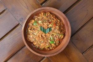 a close up Rujak Bebek or smashed fruit which is made from raw fruit crushed in a mortar and pestle and added with shrimp paste, chili and brown sugar. Indonesian traditional food photo concept.