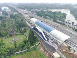 aéreo ver de un lrt estación debajo construcción, encima el Autopista y siguiente a un parque. foto