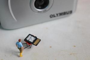 Bogor, Indonesia - Dec, 19 2022. miniature figure of a worker holding a camera memory. photo