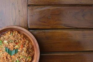 a close up Rujak Bebek or smashed fruit which is made from raw fruit crushed in a mortar and pestle and added with shrimp paste, chili and brown sugar. Indonesian traditional food photo concept.