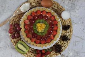 big fruit pie with toppings of strawberries, grapes, kiwi and pineapple. savory, sweet and fresh. Food concept photo. photo