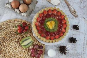 big fruit pie with toppings of strawberries, grapes, kiwi and pineapple. savory, sweet and fresh. Food concept photo. photo