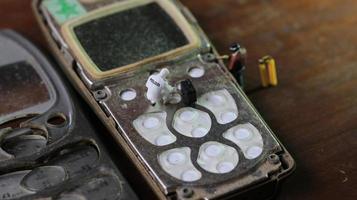 miniature figure of a technician repairing an old broken cell phone. working technician concept. photo