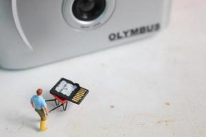 Bogor, Indonesia - Dec, 19 2022. miniature figure of a worker holding a camera memory. photo