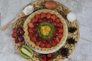 big fruit pie with toppings of strawberries, grapes, kiwi and pineapple. savory, sweet and fresh. Food concept photo. photo