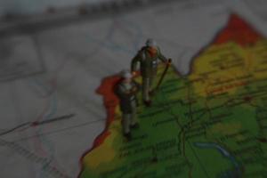 miniature figure of an explorer posing on a map or atlas photo