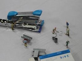Miniature figures of workers working in a staples production factory. photo