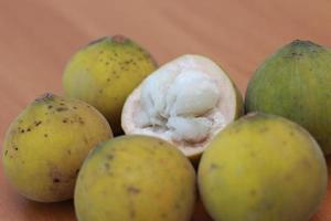 greenish yellow harp fruit isolated on money table has sweet and sour taste. Food concept photo. photo