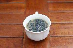 a close up of a glass of a traditional Indonesian drink called Dawet Ireng or black dawet. Indonesian traditional food photo concept.