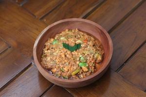 a close up Rujak Bebek or smashed fruit which is made from raw fruit crushed in a mortar and pestle and added with shrimp paste, chili and brown sugar. Indonesian traditional food photo concept.