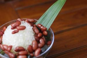 Es Kacang Merah or a cold drink made from red beans boiled with brown sugar served with coconut milk, shaved ice and covered with sweetened condensed milk chocolate and syrup. photo
