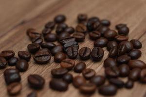 Detailed photo of coffee beans before being processed into a drink isolated on wood. Concept photo of the basic ingredients of coffee drinks.