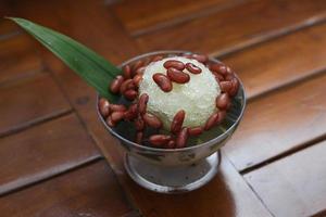 Es Kacang Merah or a cold drink made from red beans boiled with brown sugar served with coconut milk, shaved ice and covered with sweetened condensed milk chocolate and syrup. photo