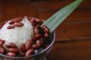 Es Kacang Merah or a cold drink made from red beans boiled with brown sugar served with coconut milk, shaved ice and covered with sweetened condensed milk chocolate and syrup. photo