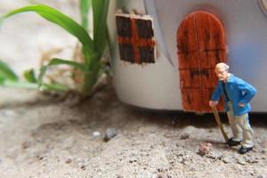 miniature figure of a grandfather who is waiting in front of the house. photo