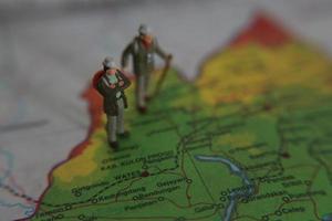 miniature figure of an explorer posing on a map or atlas photo