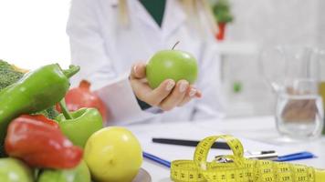 Essen gesund und organisch. Ernährungsberater empfiehlt. Ernährungsberater Arzt zeigt an Grün Apfel im seine Hand. natürlich organisch Früchte. video