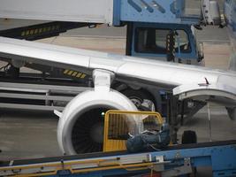 equipaje subiendo a avión mientras estacionamiento a el terminal foto