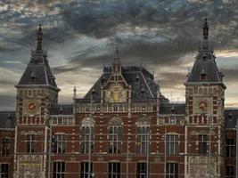 Central station in amsterdam old houses view from canals photo