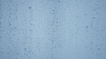 The rain droplets on the transparent glass window in the rainy day photo