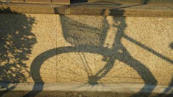 el bicicleta sombra en el pared por el calentar tarde luz de sol foto