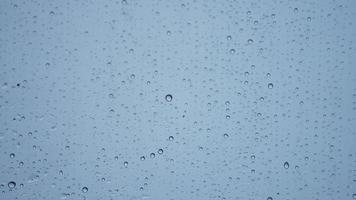 The rain droplets on the transparent glass window in the rainy day photo