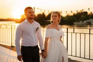 bride and groom against the backdrop of a yellow sunset photo