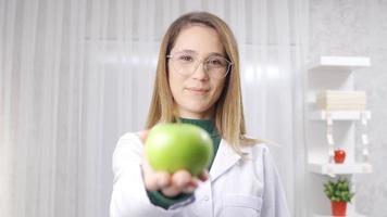 expert diététicien femme mains biologique vert Pomme à caméra. femelle diététicien soulignant le consommation de des légumes et des fruits pour en bonne santé alimentaire. video