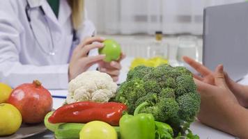 salutare stile di vita e verdura dieta concetto. un' femmina dietista prepara un' menù per sua maschio paziente per un' salutare vita. video