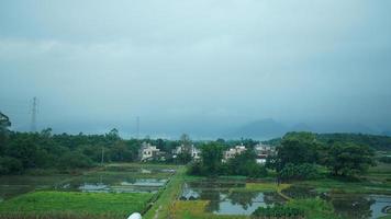 The beautiful countryside view from the runny train on the south of the China in the rainy day photo