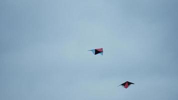 Two kites flying in the sky in the windy day photo