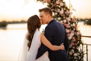 bride and groom against the backdrop of a yellow sunset photo