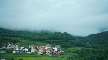 el hermosa campo ver desde el líquido tren en el sur de el China en el lluvioso día foto