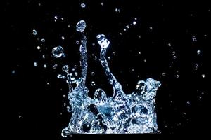 Splashing water on a black background. water droplets scattered on a black background photo