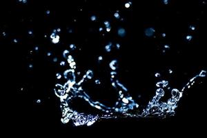 Splashing water on a black background. water droplets scattered on a black background photo