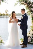 wedding ceremony on a high pier near the river photo