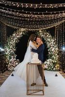 newlyweds happily cut and taste the wedding cake photo