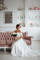 brunette bride in a tight wedding dress in a bright studio photo