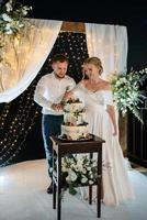 newlyweds happily cut and taste the wedding cake photo