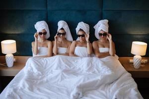 bridesmaids in towels and glasses have fun photo