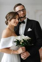 groom in a black suit tie and the bride in a bright studio photo