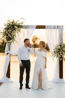 bride and groom against the backdrop of a yellow sunset photo